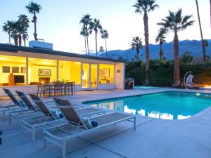 uma casa com uma piscina com espreguiçadeiras em Shag Lover em Palm Springs