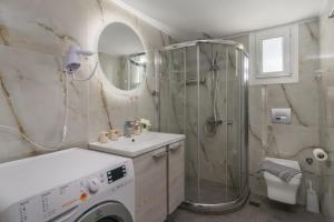 a bathroom with a shower and a washing machine at Balliu Apartment in Triovasálos +28 photos