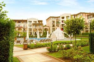 a park with a fountain and chairs and buildings at Green Life Luxury Apartment in Sozopol