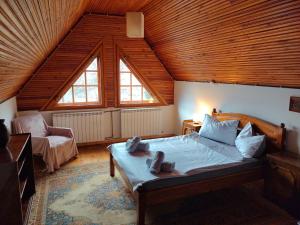 Un dormitorio con una cama grande con techo de madera. en La Șicu, en Breaza