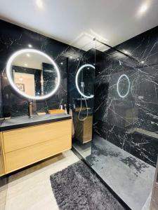 ein Bad mit einem Waschbecken und einem Spiegel in der Unterkunft Superbe T3 - 11 minutes Palais, Croisette & Plages in Cannes