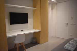 um quarto com uma secretária, uma televisão e uma cadeira em GiaChi friendly studios a Ballarò em Palermo