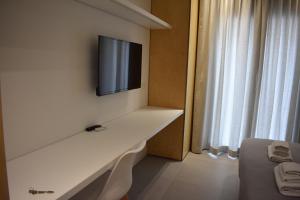 um quarto com uma televisão numa parede com uma mesa em GiaChi friendly studios a Ballarò em Palermo