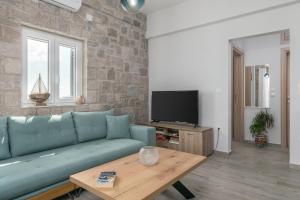 a living room with a blue couch and a table at Balliu Apartment in Triovasálos