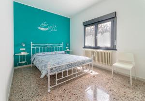 a bedroom with a bed and a blue wall at B&B A casa di Emy in Barisciano