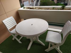 d'une table blanche et de deux chaises sur un balcon. dans l'établissement T2Bis Cosy avec 6 couchages - 100m de la mer, à La Rochelle