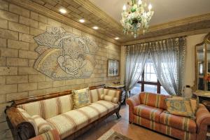salon z 2 kanapami i kamienną ścianą w obiekcie Apartment Bright w Sorrento