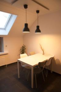 a dining room with a white table and chairs at Landzicht 05 in Ter Apel