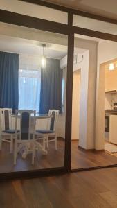Un comedor con una mesa y sillas y un espejo. en Laguna Apartament, en Brăila