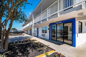 ein Geschäft vor einem Gebäude mit blauen Türen in der Unterkunft Motel 6-Corpus Christi, TX - Northwest in Corpus Christi