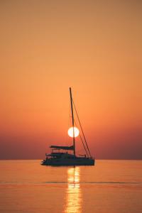 ein Segelboot im Ozean bei Sonnenuntergang in der Unterkunft Family Home Grill, Beach, Relax - WORKUM in Workum