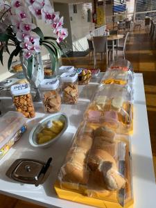 uma mesa branca com pão e outros alimentos em Pousada Maanaim em Campina Grande