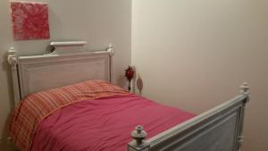 a bedroom with a bed with a pink blanket at Gîte Les Cadichons de la Grange in Saint-Péray