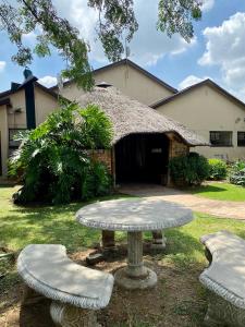 une table et des chaises devant un bâtiment dans l'établissement NamaStay, à Vereeniging