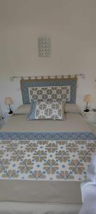イーゾラ・ロッサにあるMarinedda Exclusiveのベッド1台(青と白のシーツ、ランプ2つ付)