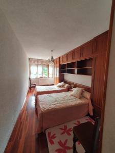 a bedroom with two beds and a window at APARTAMENTO POCO TRIGO EN POTES in Potes