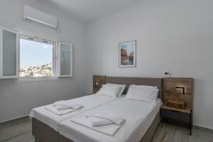 a white bedroom with a large bed with white sheets at Balliu Apartment in Triovasálos