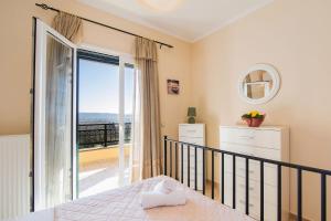 sypialnia z łóżkiem i balkonem w obiekcie Country House Marmaro w mieście Mármaron