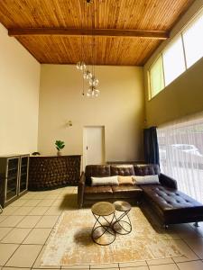a living room with a leather couch and a table at NamaStay in Vereeniging