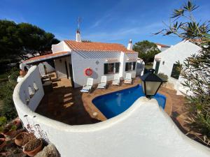 una casa con piscina frente a ella en Villa con piscina privada y gran jardín, en Cala'n Bosch