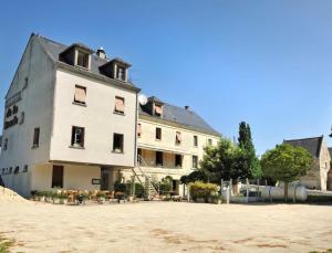 - un grand bâtiment blanc au sommet d'une plage dans l'établissement Logis Hôtel Auberge de la Bonde, à Langeais