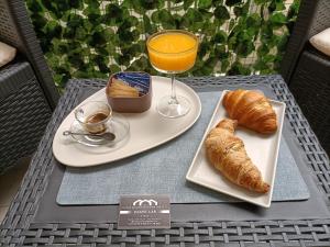 une table avec deux assiettes de nourriture et un verre de jus d'orange dans l'établissement Dante 138 Class rooms & apartments, à Bari