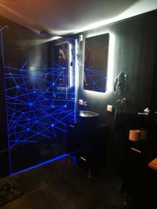 a bathroom with blue lights in a dark room at Loft d'amour in Ligné