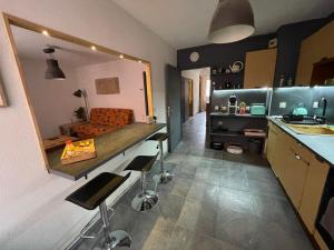 a kitchen with a counter and some stools in it at Aurillac, appartement au centre de la ville in Aurillac