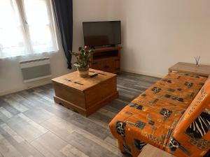 een slaapkamer met een bed en een tv op een tafel bij Aurillac, appartement au centre de la ville in Aurillac