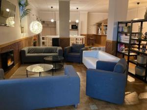 a living room with blue couches and a fireplace at Hotel Rural Mariblanca in Sacedón