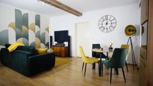 ein Wohnzimmer mit einem Sofa, einem Tisch und Stühlen in der Unterkunft FeWo Zeitreise in Görlitz