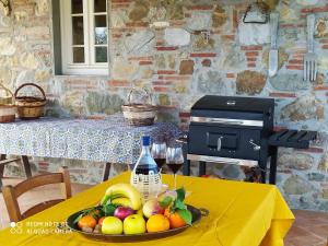 uma mesa com um prato de frutas e uma garrafa de vinho em Ringo, the true Tuscany Country House em Capannori