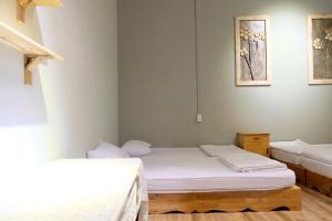 two beds in a room with white walls at NĂM ẤY HOMESTAY in Tuy Hoa
