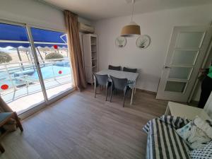 ein Wohnzimmer mit einem Tisch und Poolblick in der Unterkunft APARTAMENTO PRIMERA LINEA MAR CAMBRILS cerca PUERTO in Cambrils