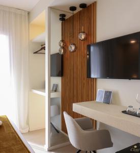 um quarto com uma secretária e uma televisão na parede em Double A Luxury Room em Olbia