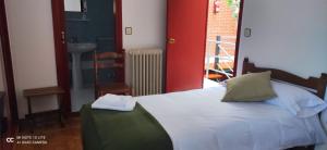 ein Schlafzimmer mit Bett und ein Badezimmer mit Waschbecken in der Unterkunft Posada Ojedo Los Ñeros in Ojedo