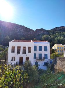 una casa blanca con una montaña en el fondo en Stefanos en Meyisti