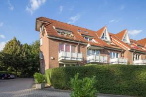 ein großes Backsteingebäude mit einer Hecke davor in der Unterkunft Ferienwohnung Schenefelder Drift in Schenefeld