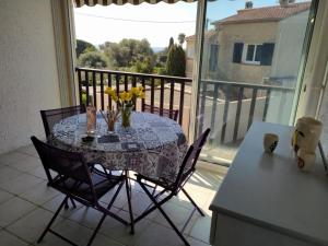 a table with chairs and a table with flowers on a balcony at Sun & Sea Apart in Bandol