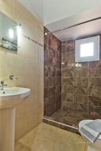 ein Bad mit einem Waschbecken und einer Dusche in der Unterkunft Albatros Studios & Apartments in Lefkos Karpathos