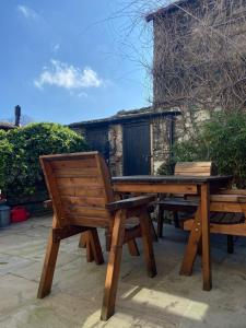 drewniany stół piknikowy i ławka na patio w obiekcie Vale Cottage w mieście Middleham