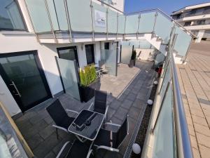 einen Balkon mit Stühlen und einem Tisch auf einem Gebäude in der Unterkunft Kern Apartments in Rust