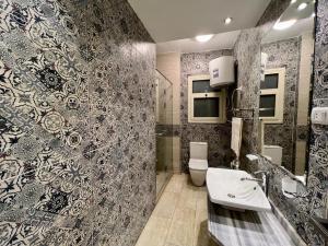 a bathroom with a toilet and a sink at Alexander House in Alexandria +104 photos