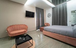 a hotel room with a bed and a chair at Intimity Luxury Rooms in Qualiano