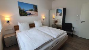 Un pat sau paturi într-o cameră la Ferienwohnungen "Godewind", Appartements mit Balkon oder Terrasse