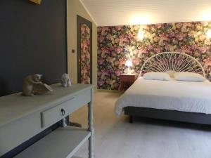 a bedroom with a bed and a floral wall at La petite auberge in Villefranche-du-Périgord