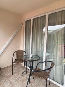 a glass table and two chairs on a balcony at Jorjadze street 23 in Borjomi