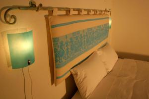 ein Hotelzimmer mit einem Bett mit einem Kopfteil und einer Lampe in der Unterkunft Note Sulla Piazza in Cagliari