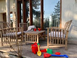 a patio with a table and chairs and toys on the floor at La villa dans les pins in Quend