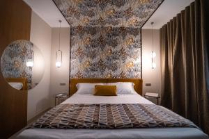 a bedroom with a large bed with a floral wallpaper at Hotel Liola' in Castrocielo